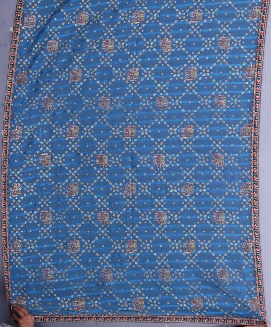 Blue bandhani saree with elephant motifs photographed flat, the input photo
